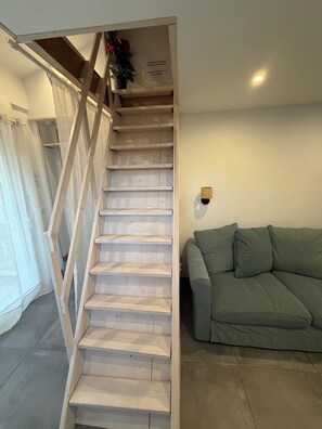 Eine Treppe mit Holzbodenstufen und Geländer, die zu einer oberen Etage führt.