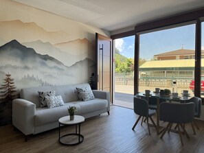 Una sala de estar moderna con sofá, mesa de centro y comedor.