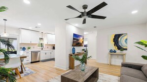 A modern living room with a dining area, a kitchen, and a ceiling fan. - Cozy Ridge Manor Retreat - SUMMER SPECIAL (Ridge Manor)