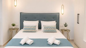 A modern bedroom with a large bed, two bedside tables, and pendant lighting. - Oceana Suites Villas Infinity Pool Deluxe Villa (Apokoronas)