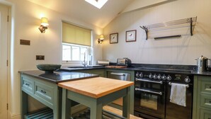 Una cucina moderna con un lucernario, forno integrato e isola in legno.