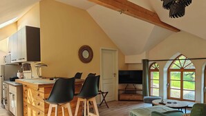 A spacious loft with a kitchen, dining area, and seating area. - Wellness apartment: private sauna, hot tub – last-minute (Großharthau)