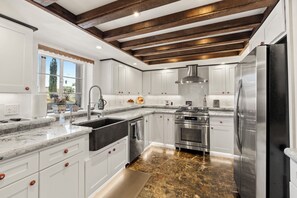 A modern kitchen with white cabinetry, a stainless steel refrigerator, and a built-in oven. - Luxury Point Loma Stay - Central, Coastal & Unique (San Diego)