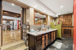 A bathroom with a large mirror, wooden cabinets, and a marble countertop. - Luxury Point Loma Stay - Central, Coastal & Unique (San Diego)