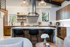 A modern kitchen with a central island, pendant lighting, and wooden cabinetry. - West Vail Home - Hot Tub, Fireplace & Steps to Bus (Vail)