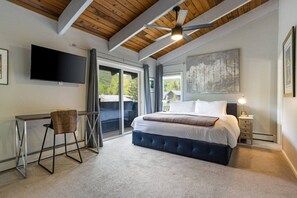 A bedroom with a bed, a desk, a chair, a ceiling fan, and a large window. - West Vail Home - Hot Tub, Fireplace & Steps to Bus (Vail)