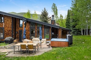 A modern building with a brick exterior, large windows, and a hot tub in the backyard. - West Vail Home - Hot Tub, Fireplace & Steps to Bus (Vail)