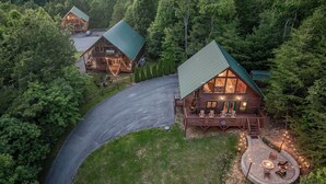 A log cabin with a curved driveway, a deck with outdoor seating, and a fire pit area. - Summit Views | Hot Tub, Sauna, Fire Pit & Game Room, Near Gatlinburg (Gatlinburg)
