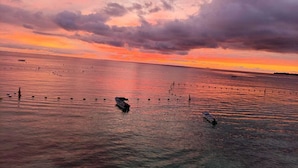 Ein ruhiges Meer bei Sonnenuntergang mit Booten und Bojen.