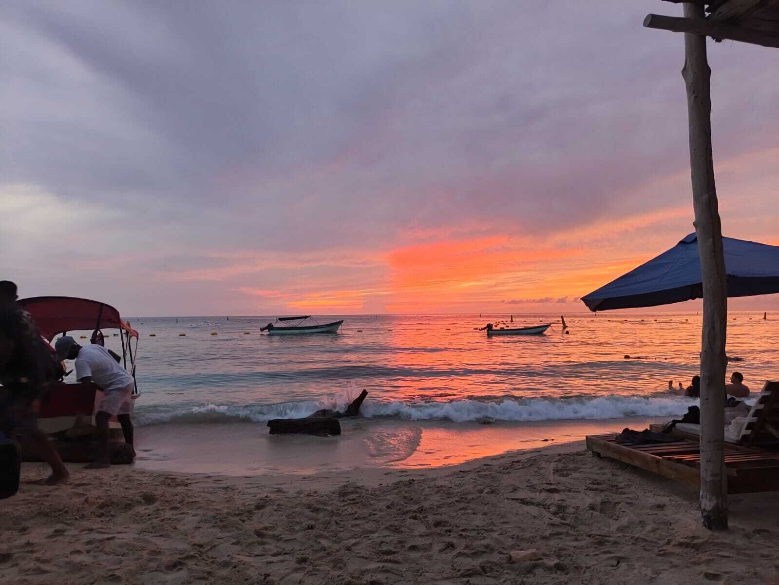 A beach with boats, a wooden structure, and a sandy shore.