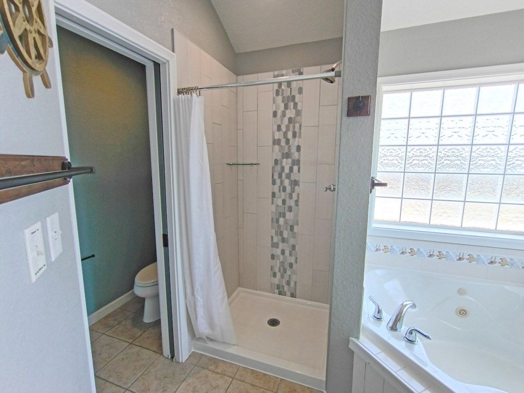 Ein Badezimmer mit Dusche, Toilette und Badewanne.