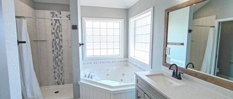 A bathroom with a walk-in shower, a freestanding bathtub, and a vanity with a mirror.