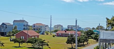 A residential area with houses, a grassy field, and a road.