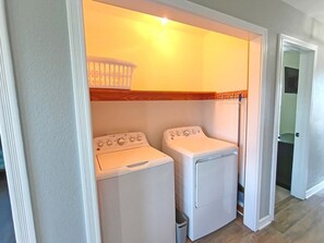 A laundry room with two white front-loading washing machines and a drying rack. - 7Bed steps to ocean/Private pool & Hot tub/Pets OK (Waves)