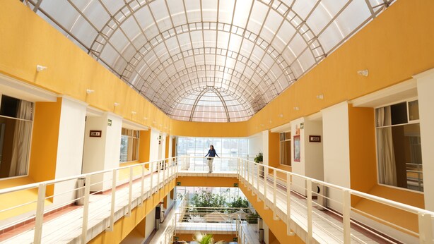 A multi-level atrium with a glass ceiling, yellow walls, and a central staircase. - HOTEL MEDITERRANEO, located right in the heart of the city. Complimentary breakfast (Tulancingo)