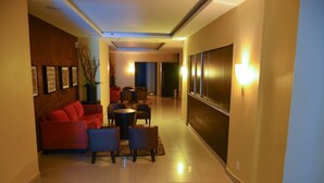 A hotel corridor with a sofa, chairs, a small table, and a decorative plant. - HOTEL MEDITERRANEO, located right in the heart of the city. Complimentary breakfast (Tulancingo)