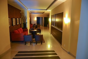 A hotel corridor with a sofa, chairs, a small table, and a decorative plant. - HOTEL MEDITERRANEO, located right in the heart of the city. Complimentary breakfast (Tulancingo)