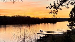 Une vue paisible sur un lac, avec un quai et des bateaux amarrés.