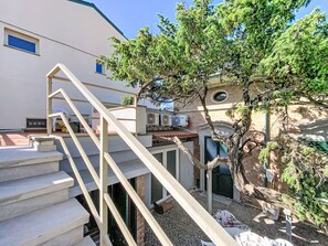A staircase leading to a building with a tree in the foreground. - Oblo e Ginepro sul mare by Interhome (Cecina)