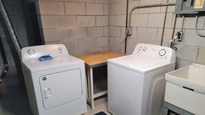 A laundry area with two front-loading washing machines and a sink. - Remodeled Rossford Lower Apartment (Rossford)