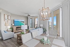 Ein modernes Wohnzimmer mit Fernseher, einer Couch und einem Essbereich.