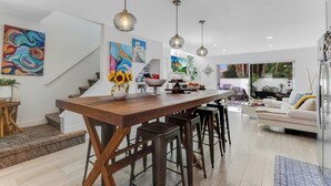 Una cocina moderna con una isla de madera, taburetes de bar e iluminación colgante.
