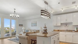 A modern kitchen with white cabinets, a central island, and pendant lighting. - Laketown Wharf 318 (Panama City Beach)