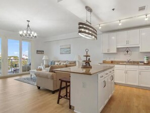 A modern kitchen with white cabinets, a central island, and pendant lighting. - Laketown Wharf 318 (Panama City Beach)