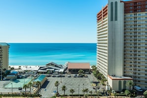 Ein Hotel mit Parkplatz, ein Gebäude mit rotem Dach und Blick auf den Ozean.