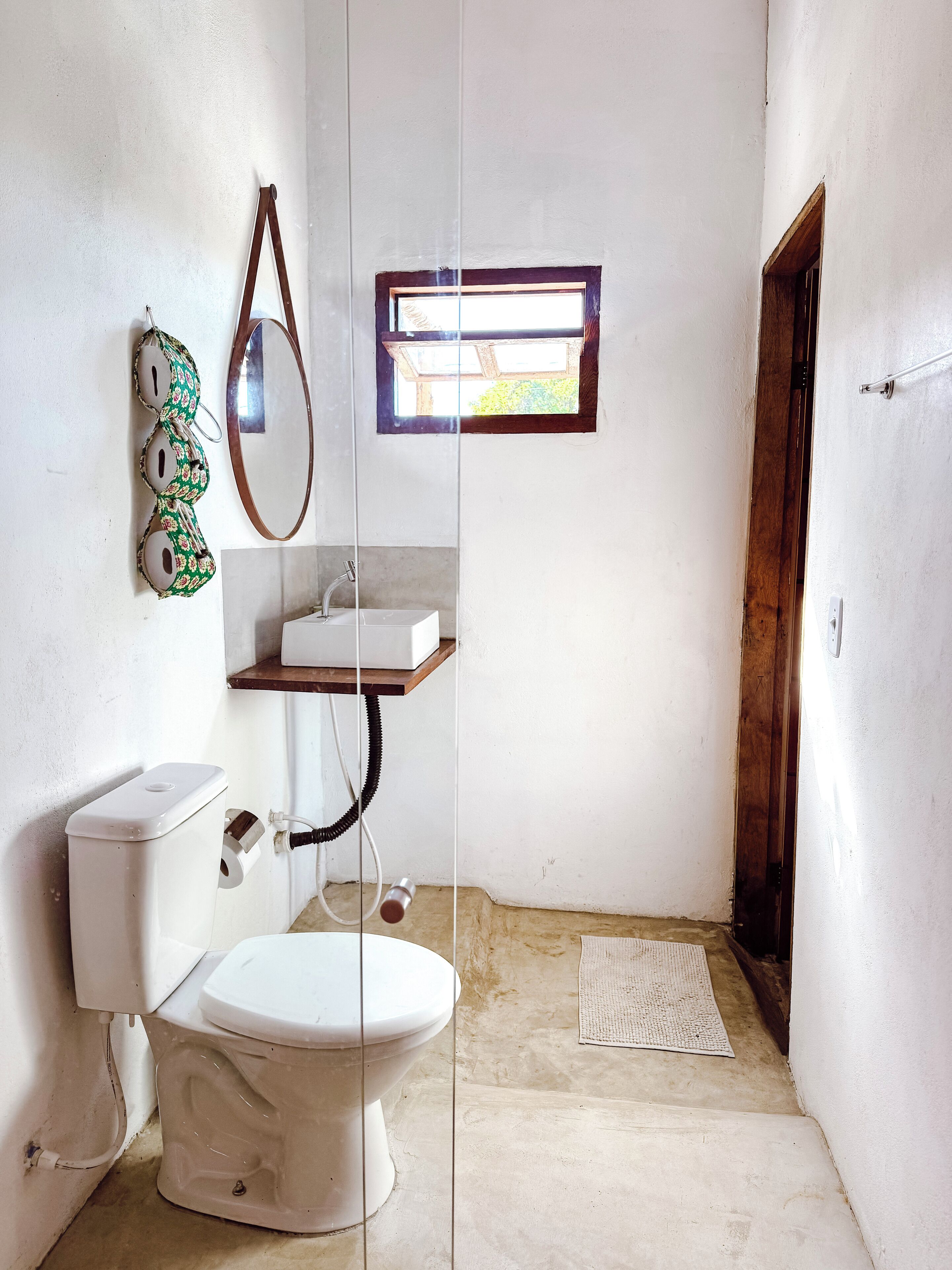 Un baño pequeño con inodoro, lavamanos y espejo.