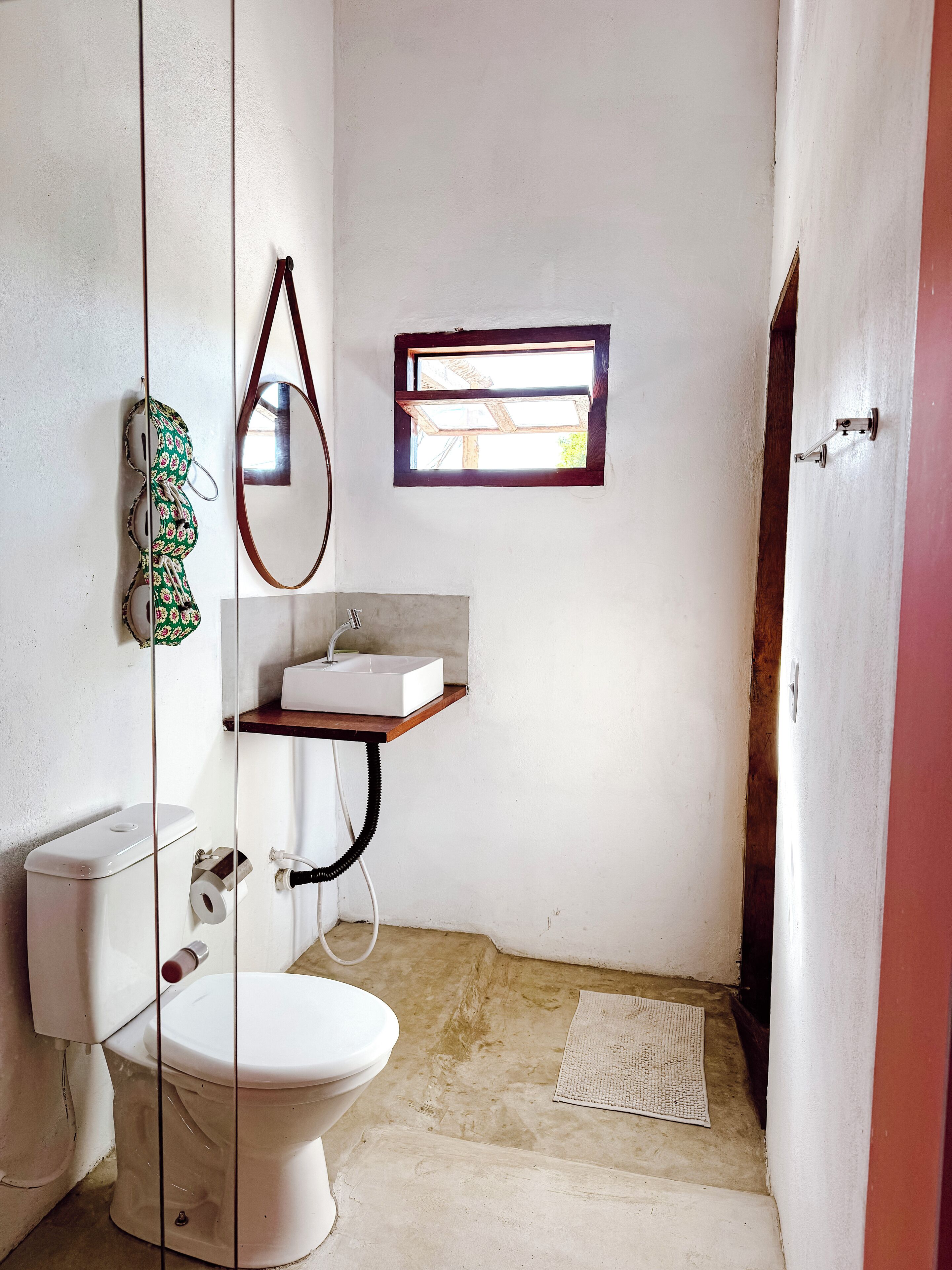 Un baño pequeño con inodoro, lavabo y espejo.