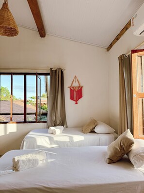 A room with a bed, a window, and a hanging macrame wall decoration. - praia mar pousada (Porto Seguro)