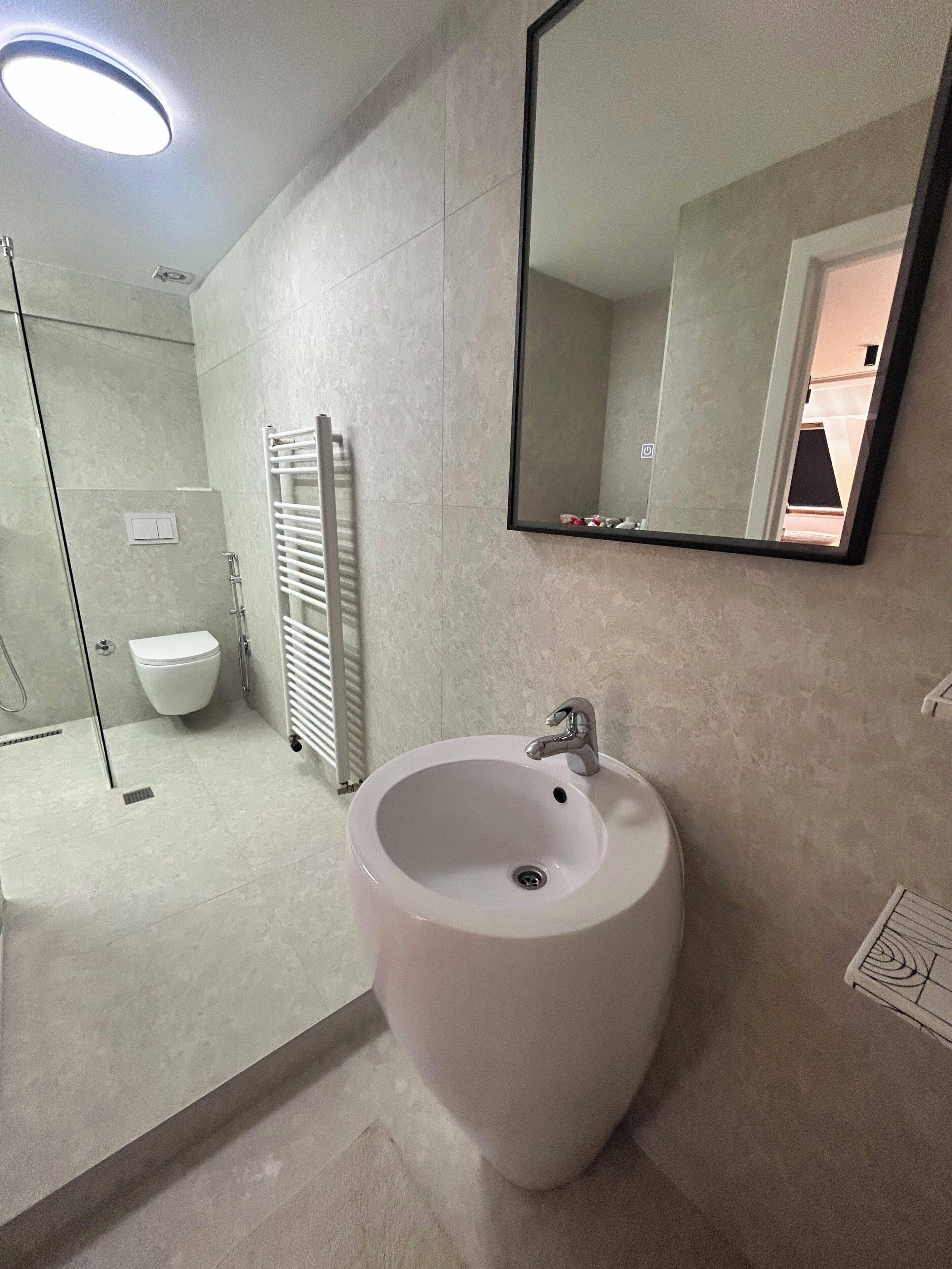 A bathroom with a sink, mirror, and toilet.