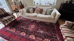 A living room with a sofa, patterned rug, and decorative items. - Cambridge Home, 100 m from bus stop to city centre, 2 km walking to city centre (Cambridge)