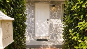 A pathway leading to a stone-walled building with a white door, surrounded by greenery and stone accents. - Private Pool Oasis Near Wynwood, Midtown & Beaches (Miami)