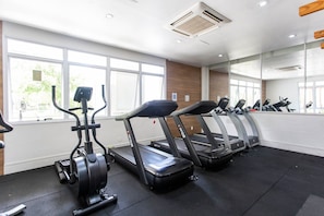 A gym with treadmills, an elliptical, and a mirrored wall. - Affinity for Life (São Paulo)