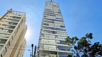 Un immeuble de grande hauteur, avec de nombreux étages, de grandes fenêtres et un ciel dégagé.