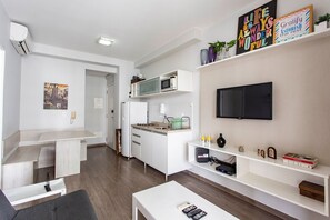 A modern kitchen with a microwave, sink, and a flat-screen TV mounted on the wall. - Affinity for Life (São Paulo)