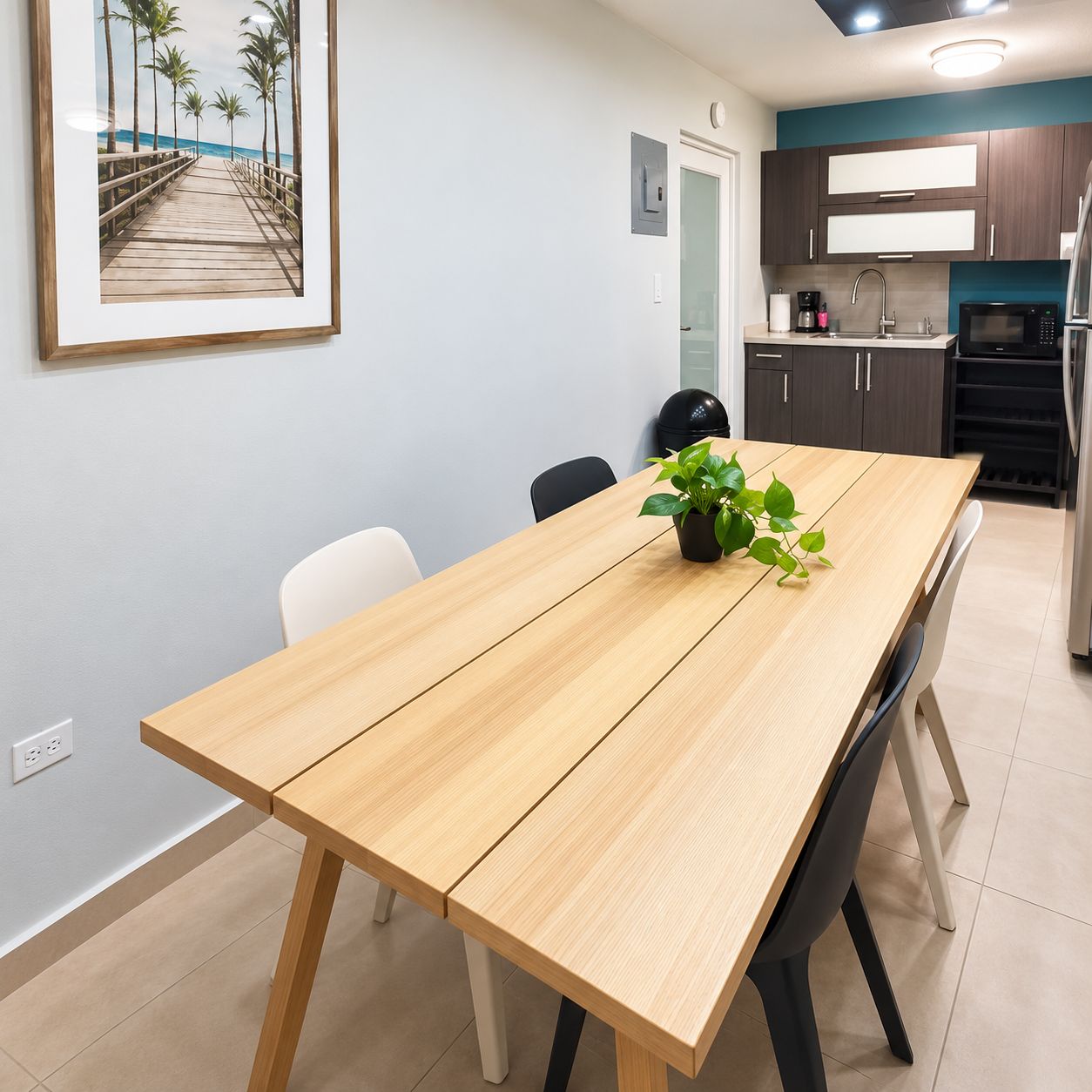 A dining area with a wooden table, chairs, and a potted plant.