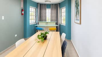 Un comedor moderno con una mesa de madera larga, sillas y una planta en maceta.