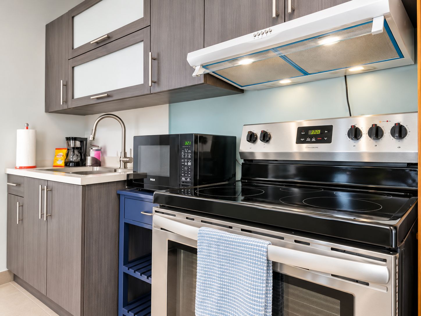 Een moderne keuken met een magnetron, fornuis en oven.