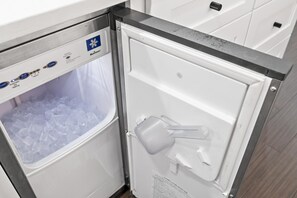 A refrigerator with a freezer compartment containing ice cubes, a water dispenser, and a control panel with various settings. - Emerald Hideout (Miramar Beach)