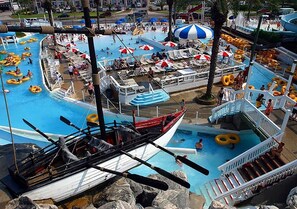 Un parc aquatique doté de plusieurs piscines, de pédalos et de bouées gonflables.