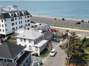 Un edificio costero con varias unidades, un estacionamiento y vistas al mar.