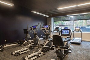 A gym with stationary bikes, treadmills, and a rowing machine. - Upscale Apartment Near Lake Michigan · Sleeps 6-7 (Milwaukee)