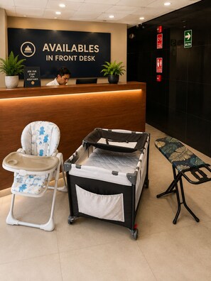 Ein Empfangsbereich mit einem Schreibtisch, einer Wickelstation und einem Kinderwagen.