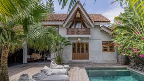 A house with a pool, wooden deck, and lounge chairs. - Architectural 2 bedroom Pool Villa Berawa (Kecamatan Kuta Utara)