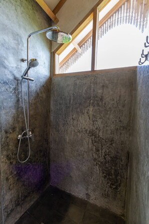 Eine Dusche mit Handbrause und Wandarmatur.