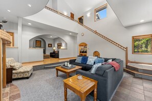 A spacious living area with a staircase, a sofa set, and a coffee table. - Blue River Retreat - Private Hot Tub & Mtn Views (Blue River)