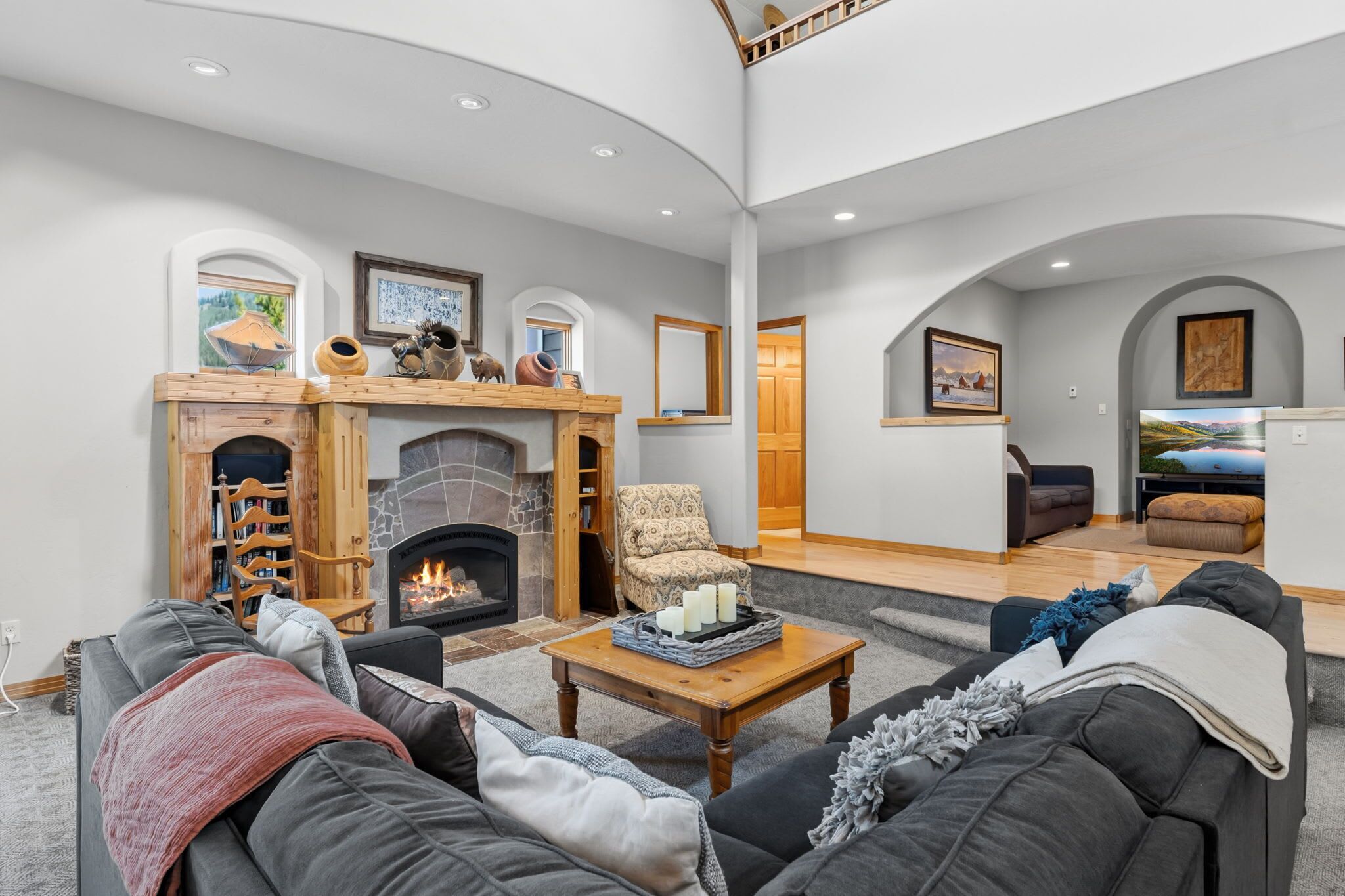 A spacious living room with a fireplace, comfortable seating, and a television.